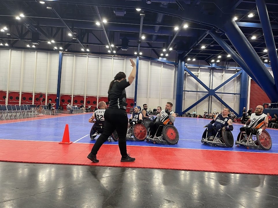 A person in wheelchairs on a blue and red court
Description automatically generated