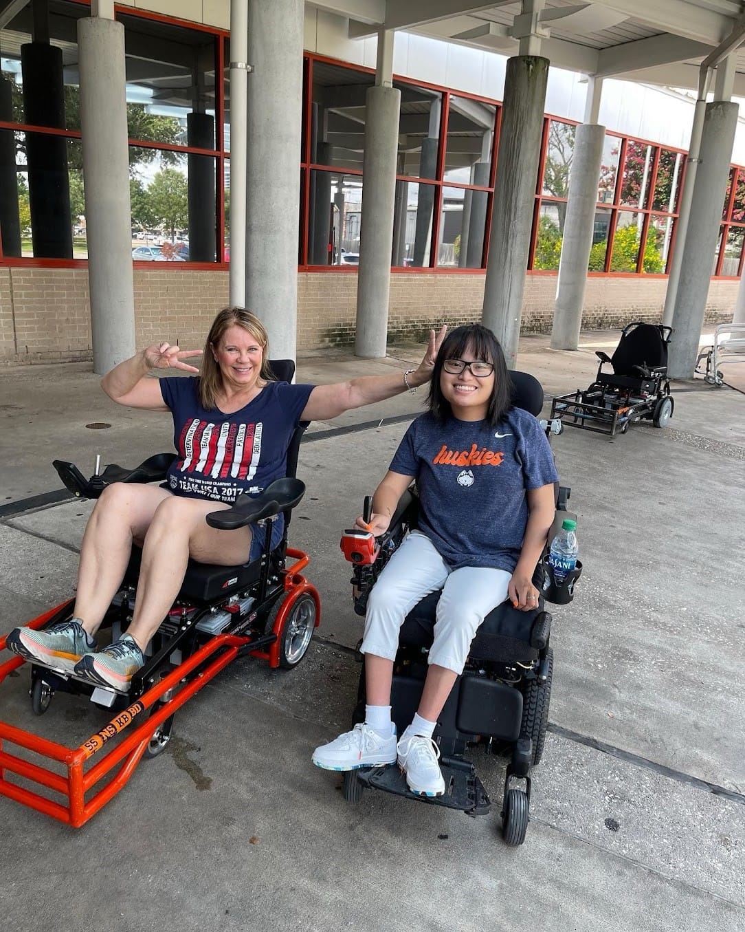 A person and a child in wheelchairs
Description automatically generated
