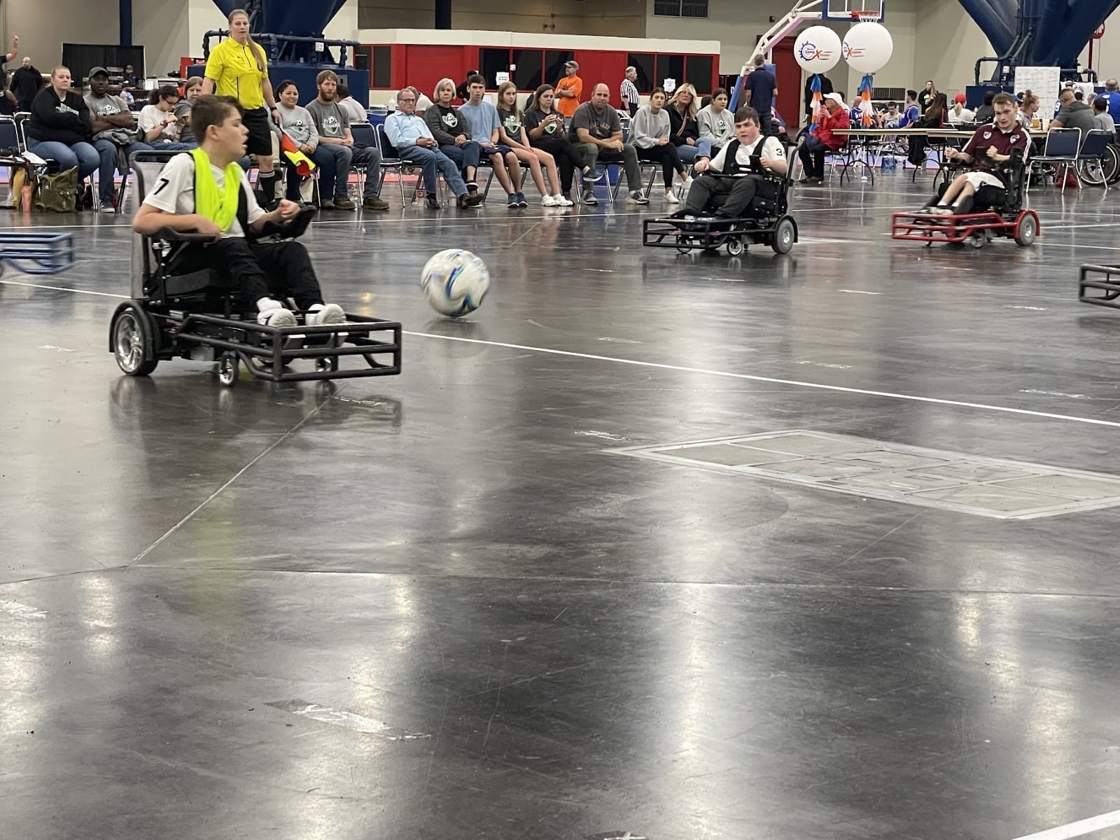 A group of people in wheelchairs playing football
Description automatically generated